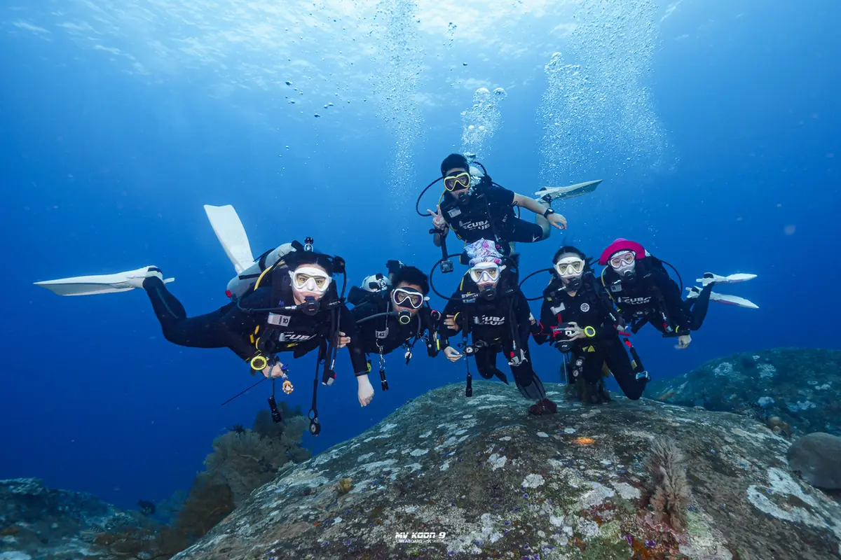 A group of Open Water students kneeling on the reef